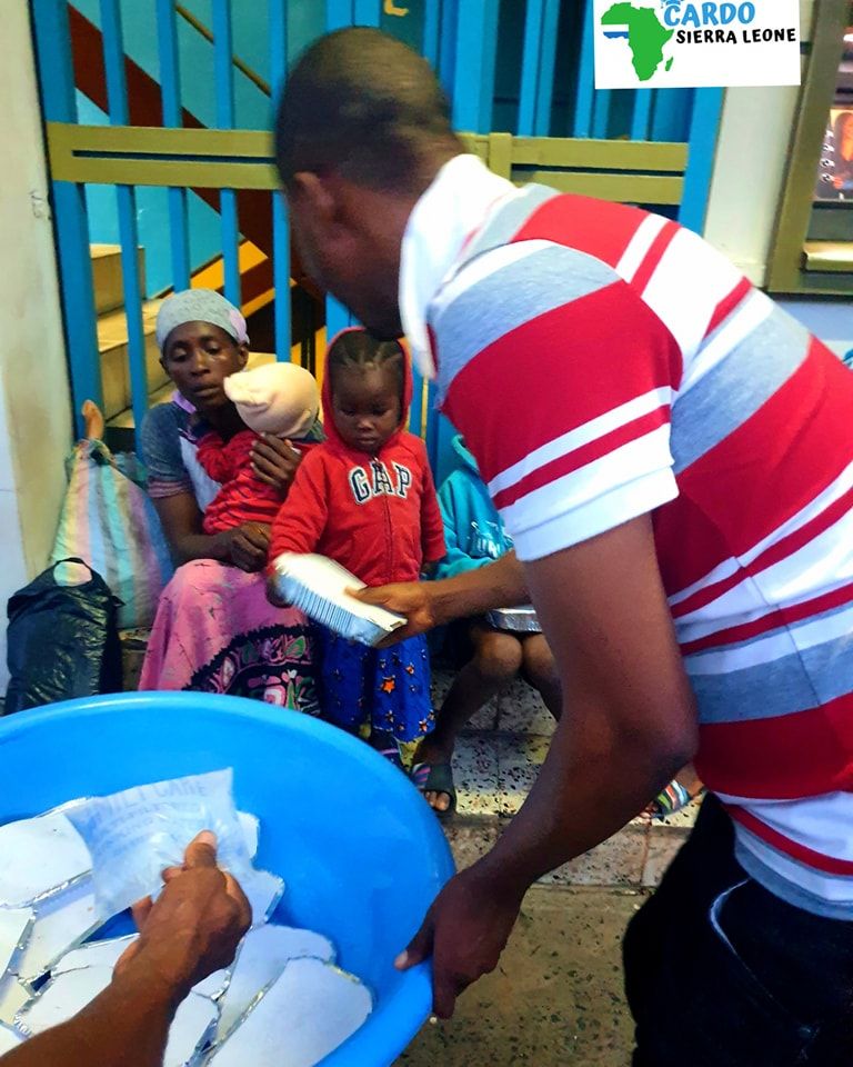 A CARDO volunteer serving food in Freetown