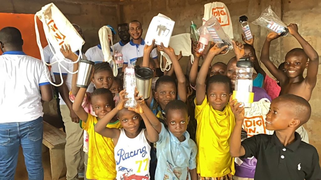 Children holding school supplies and containers in Kroo Bay