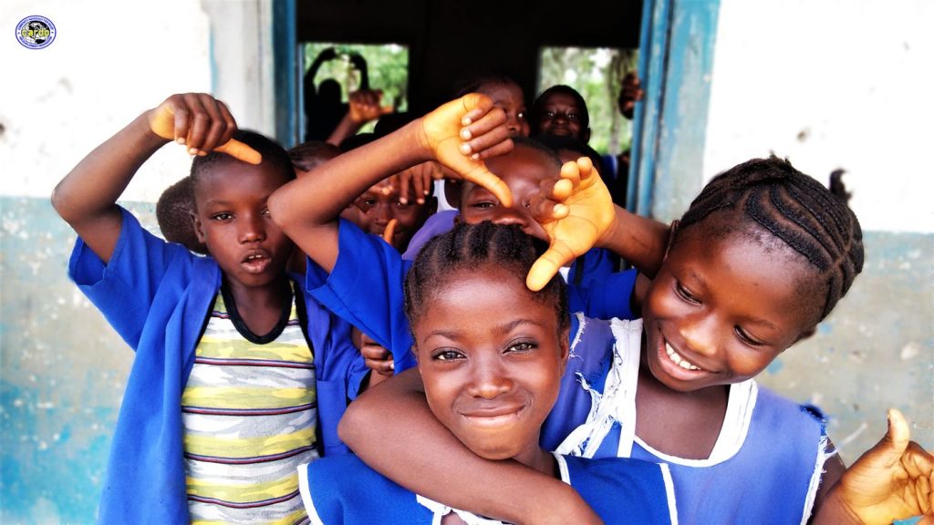 Smiling pupils in blue school uniforms in a doorway